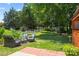 Beautiful backyard featuring a fire pit, outdoor seating, white picket fence, mature trees, and lush green grass at 6720 Long Nook Ln, Indian Trail, NC 28079