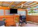 Outdoor covered deck with seating, grill, mounted TV, fan, plants, and finished wood construction at 6720 Long Nook Ln, Indian Trail, NC 28079