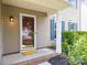 Inviting front entrance featuring a decorative door, column, a yellow doormat, and well-maintained landscaping at 6720 Long Nook Ln, Indian Trail, NC 28079