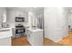 Modern kitchen featuring white cabinets, stainless steel appliances, and functional island, creating an efficient workspace at 6720 Long Nook Ln, Indian Trail, NC 28079