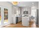Well-lit kitchen featuring white cabinets, stainless steel appliances, a kitchen island, and access to patio at 6720 Long Nook Ln, Indian Trail, NC 28079