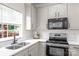 Modern kitchen with white cabinets, quartz countertops, and stainless steel appliances at 6720 Long Nook Ln, Indian Trail, NC 28079