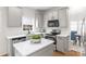 Well-lit kitchen featuring stainless steel appliances, white cabinets, countertops, and an island with green decor at 6720 Long Nook Ln, Indian Trail, NC 28079