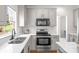 Bright kitchen features white cabinetry, stainless steel appliances, and a double sink with a backyard view at 6720 Long Nook Ln, Indian Trail, NC 28079