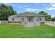 A backyard with a well-maintained lawn, a deck with furniture, and a fence at 7478 Pine Ridge Dr, Denver, NC 28037