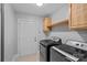 Functional laundry room with modern washer and dryer, ample cabinetry, and access to the exterior at 7478 Pine Ridge Dr, Denver, NC 28037