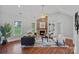 Cozy living room with a fireplace, vaulted ceilings, large windows, and hardwood floors at 7478 Pine Ridge Dr, Denver, NC 28037