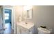 Clean bathroom with a white vanity, a modern faucet, bright lighting, and a view into an adjoining room at 8012 Red Lantern Rd, Indian Trail, NC 28079