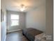 Neutral bedroom features a ceiling fan, window, light-colored walls, and wood flooring at 8012 Red Lantern Rd, Indian Trail, NC 28079