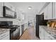Well-lit kitchen featuring stainless steel appliances, granite countertops, white subway tile, and wood-look flooring at 8012 Red Lantern Rd, Indian Trail, NC 28079