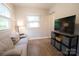 Cozy sitting room with a sofa, TV, shelving unit, and a sunlit window at 8012 Red Lantern Rd, Indian Trail, NC 28079