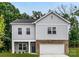 Charming two-story home with gray siding, brick accents, a two-car garage, and manicured landscaping at 8036 Joy Crossing Ln, Charlotte, NC 28214