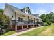 Spacious covered porch with black railings, features columns, ceiling fans and plantings, inviting outdoor living and relaxation at 814 Carved Oak Ct, York, SC 29745