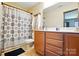 Bright bathroom with a shower-tub combination, wooden vanity, and ample counter space at 8152 Chilkoot Ln, Locust, NC 28097