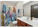This bathroom has a patterned shower curtain, wooden vanity, and a modern countertop at 8152 Chilkoot Ln, Locust, NC 28097