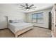 Comfortable bedroom with a ceiling fan, soft carpet, a large window, and a cozy bed at 8152 Chilkoot Ln, Locust, NC 28097