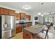 Open concept kitchen with stainless steel appliances, a breakfast bar, and a view into the living area at 8152 Chilkoot Ln, Locust, NC 28097