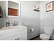 Stylish powder room features a modern vanity, toilet, decorative shelf, and framed art at 8152 Chilkoot Ln, Locust, NC 28097