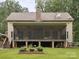 Exterior view of home with large screened-in back patio with storage underneath and brick chimney at 820 King Rd, Clover, SC 29710
