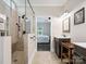 Well-lit bathroom with a tiled shower, dark wood vanities, and modern fixtures at 820 King Rd, Clover, SC 29710