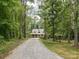 Charming home exterior featuring a long driveway winding through a tranquil wooded setting at 820 King Rd, Clover, SC 29710
