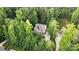 An aerial view of a house surrounded by lush green trees, a large driveway, and a well-manicured lawn at 8214 Aspen Ct, Mint Hill, NC 28227