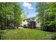 Spacious backyard with a well-maintained lawn, screened porch, and abundant greenery, perfect for outdoor activities at 8214 Aspen Ct, Mint Hill, NC 28227