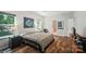 Bright bedroom features hardwood floors, a large window, and a stylish accent painting at 8214 Aspen Ct, Mint Hill, NC 28227