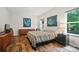 Sunlit bedroom with hardwood floors, decorative paintings, and comfortable furnishings at 8214 Aspen Ct, Mint Hill, NC 28227