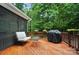 Wood deck with a cozy seating arrangement and grill, backed by lush greenery, perfect for outdoor entertaining at 8214 Aspen Ct, Mint Hill, NC 28227