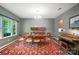 An elegant dining room with stylish furniture, a colorful rug, piano, and ample natural light at 8214 Aspen Ct, Mint Hill, NC 28227