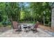 Outdoor fire pit with seating and landscaping, ideal for cozy gatherings surrounded by lush trees at 8214 Aspen Ct, Mint Hill, NC 28227