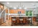 Kitchen island with bar stool seating, modern appliances, stone countertops, wood cabinets, and tile backsplash at 8214 Aspen Ct, Mint Hill, NC 28227