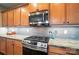 The kitchen features stone countertops, stainless steel appliances, a tile backsplash, and plenty of cabinet space at 8214 Aspen Ct, Mint Hill, NC 28227