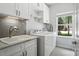 Bright laundry room with modern washer and dryer, ample counter space, and storage cabinets at 8214 Aspen Ct, Mint Hill, NC 28227