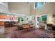 Open concept living room and kitchen, featuring vaulted ceilings, a sliding glass door to the deck, and ample natural light at 8214 Aspen Ct, Mint Hill, NC 28227