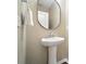Elegant powder room featuring a pedestal sink, decorative mirror, and neutral wall color at 8214 Aspen Ct, Mint Hill, NC 28227