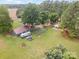 Aerial view of a property with multiple buildings, mature trees, and large grassy areas at 835 Holshouser Rd, Rockwell, NC 28138