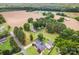 An aerial view showcases a rural home near farmland, featuring mature trees and ample land at 835 Holshouser Rd, Rockwell, NC 28138