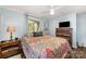 Light-filled bedroom with blue walls, wood floors, a patterned bed, and a ceiling fan at 835 Holshouser Rd, Rockwell, NC 28138