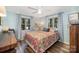Cozy bedroom featuring wood floors, blue walls, and a bed dressed in colorful patterned bedding at 835 Holshouser Rd, Rockwell, NC 28138