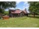 Charming home with a covered porch, landscaped yard and brick well house surrounded by lush greenery and mature trees at 835 Holshouser Rd, Rockwell, NC 28138