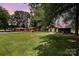 Expansive green lawn with a variety of buildings and mature trees, offering a serene, estate-like setting at 835 Holshouser Rd, Rockwell, NC 28138