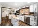 Open kitchen with a movable island, stainless steel appliances, white cabinets, and wood floors at 835 Holshouser Rd, Rockwell, NC 28138