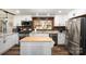 Bright kitchen with a movable island, white cabinets, granite countertops, and stainless-steel appliances at 835 Holshouser Rd, Rockwell, NC 28138