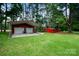 Outbuildings and garages with ample parking and storage space on a well-maintained lawn at 835 Holshouser Rd, Rockwell, NC 28138