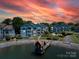 Scenic exterior view of blue condominiums and a lake with a gazebo at sunset at 1018 Southwest Sw Dr # 18, Davidson, NC 28036
