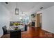 Sunlit living room with a stone fireplace, hardwood floors, and a glass table with black chairs at 1018 Southwest Sw Dr # 18, Davidson, NC 28036