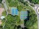 Aerial view of community tennis and pickleball courts surrounded by lush trees and green spaces at 1018 Southwest Sw Dr # 18, Davidson, NC 28036