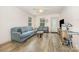 Cozy living room featuring hardwood floors, a comfortable blue couch, and natural light at 1019 Richard St, Salisbury, NC 28144